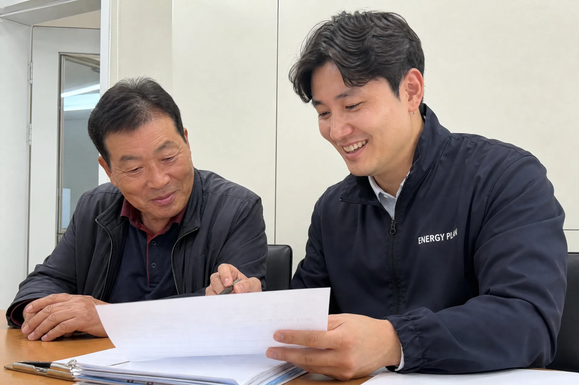 공장 관계자와 자료를 함께 살펴보는 에너지플랜 담당자